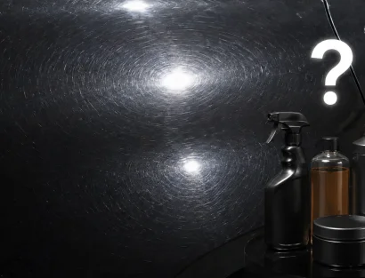 Close-up of a black car hood covered in circular swirl marks, with detailing product bottles nearby and a glowing question mark symbolizing the query "how do you remove swirl marks?"